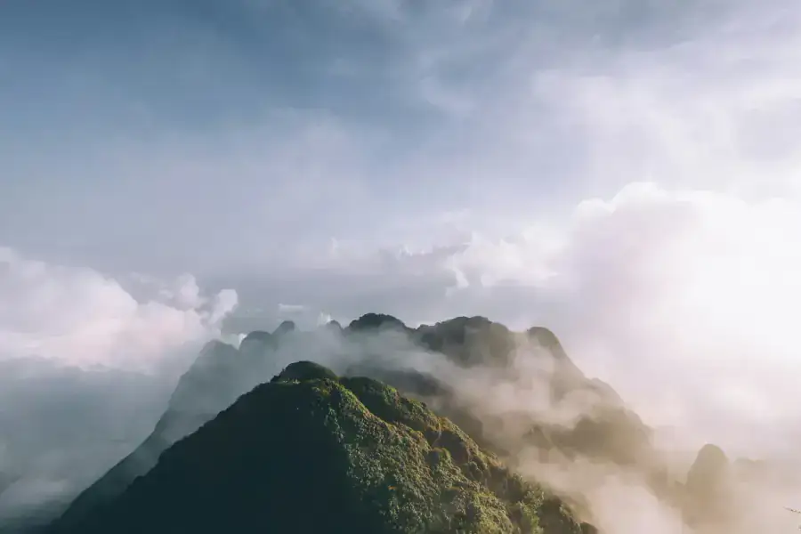 Trekkers on a ridge above clouds